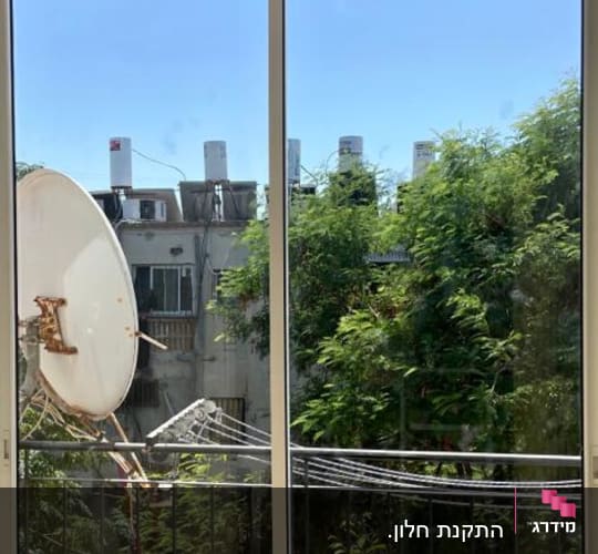 חלון אלומיניום עם נוף לעצים וצלחת לוויין